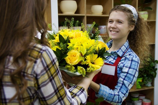 Monthly Flower Delivery Club Woman receiving flowers at shop Why Use A Monthly Flower Delivery Club? ❀Fairy Circle Garden